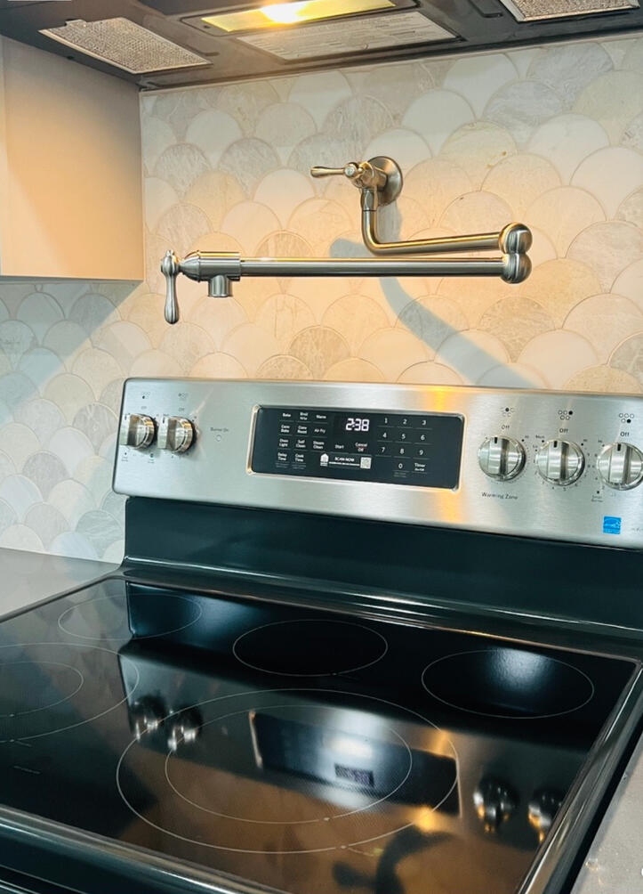 Bianco Orion scalloped marble backsplash introducing movement, texture, and timeless character.