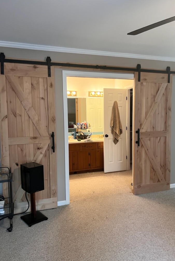 The entry was reimagined with custom natural wood barn doors, creating architectural interest while improving access to the primary suite.