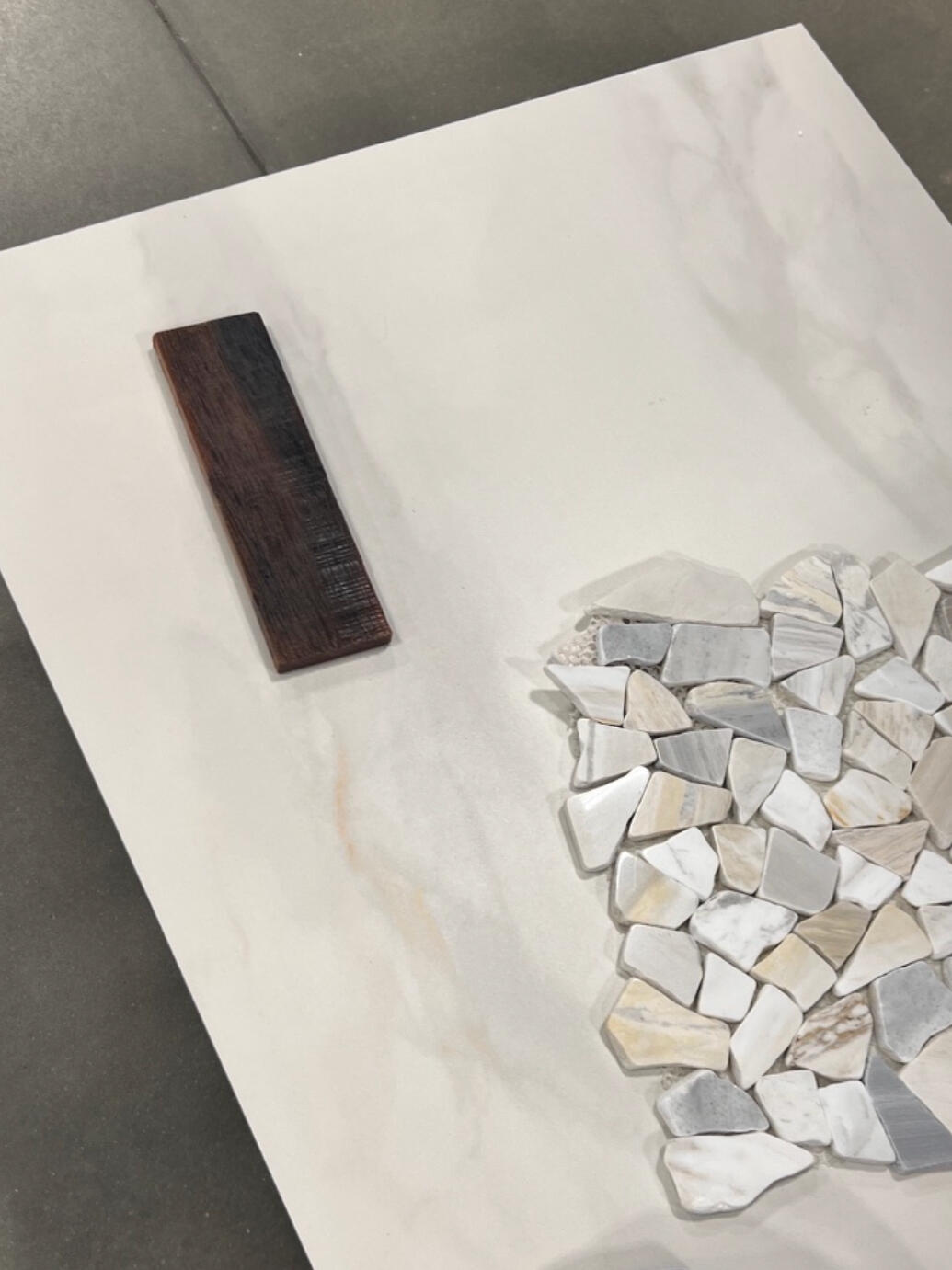 Every finish was intentionally selected to create balance: warm wood tones, soft marble-inspired porcelain, textured stone accents, and contemporary black fixtures.
